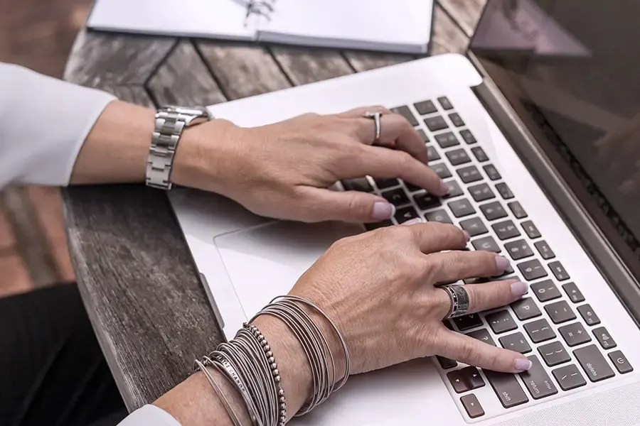 Hände auf einer Laptop-Tastatur